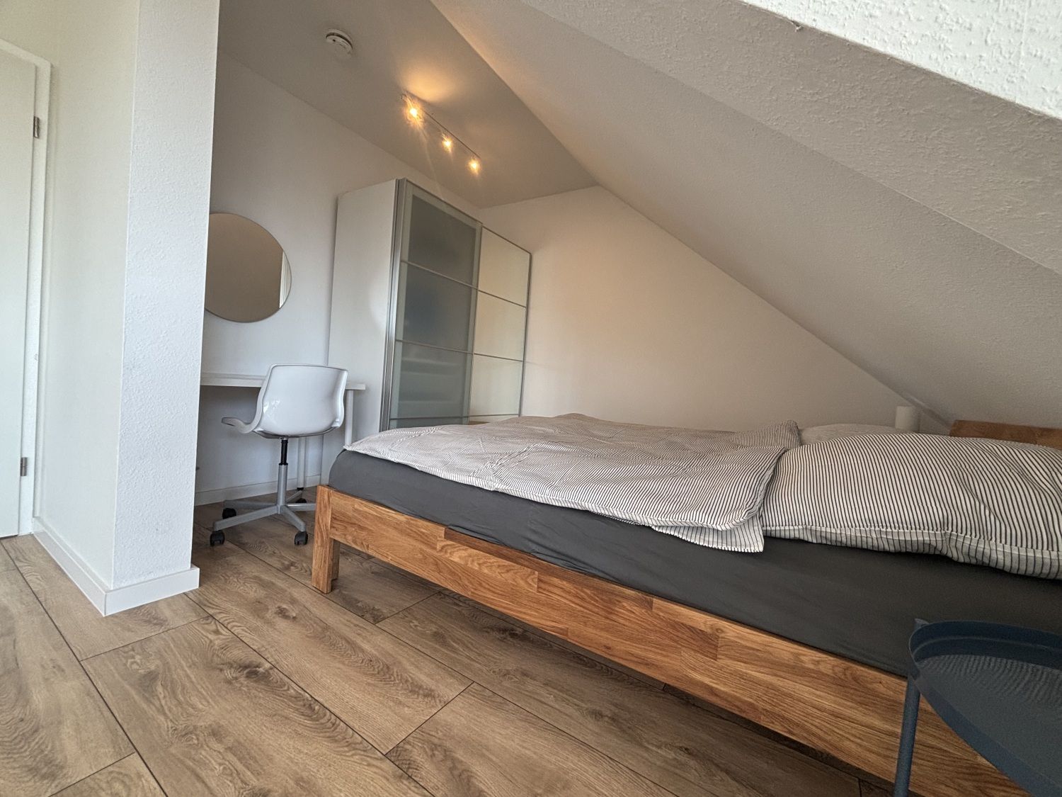 Doppelbett neben dem Arbeitsplatz mit Schreibtisch und Stuhl