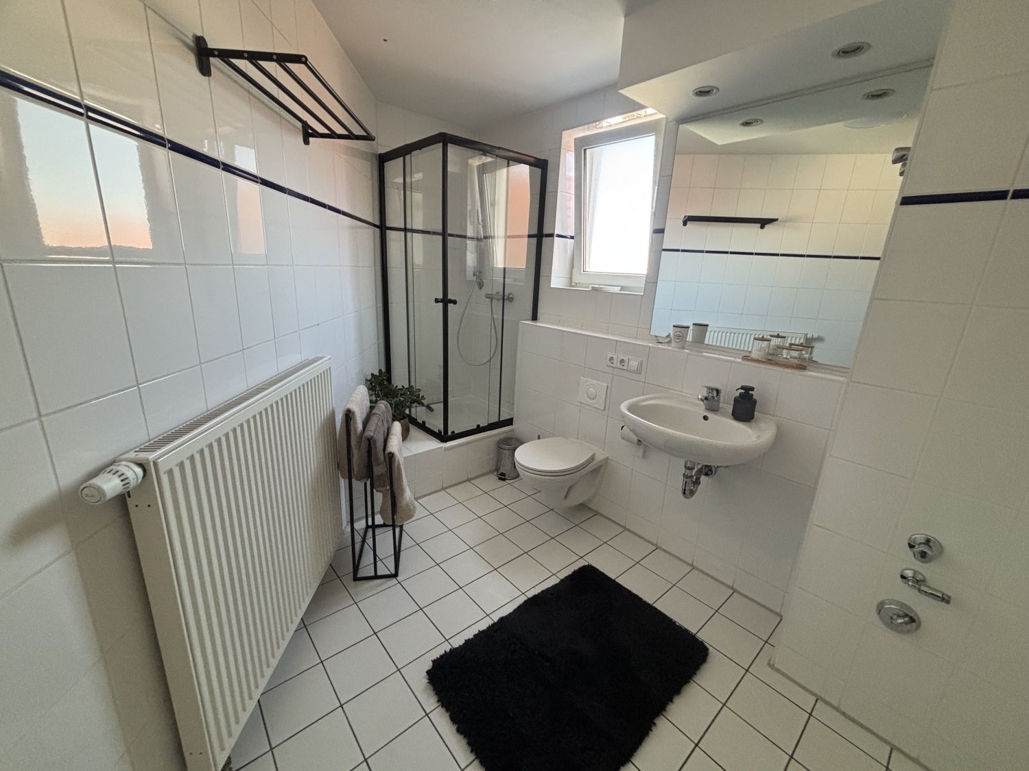 Badezimmer mit ebenerdiger Dusche, Waschbecken und WC
