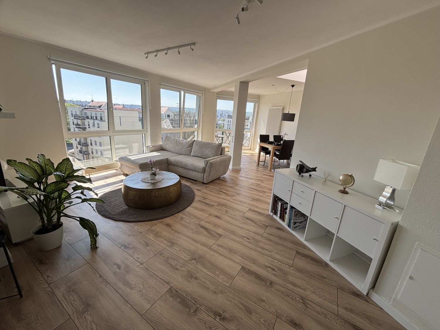 Offener Wohnraum mit Sofa, Pflanzen und Essbereich