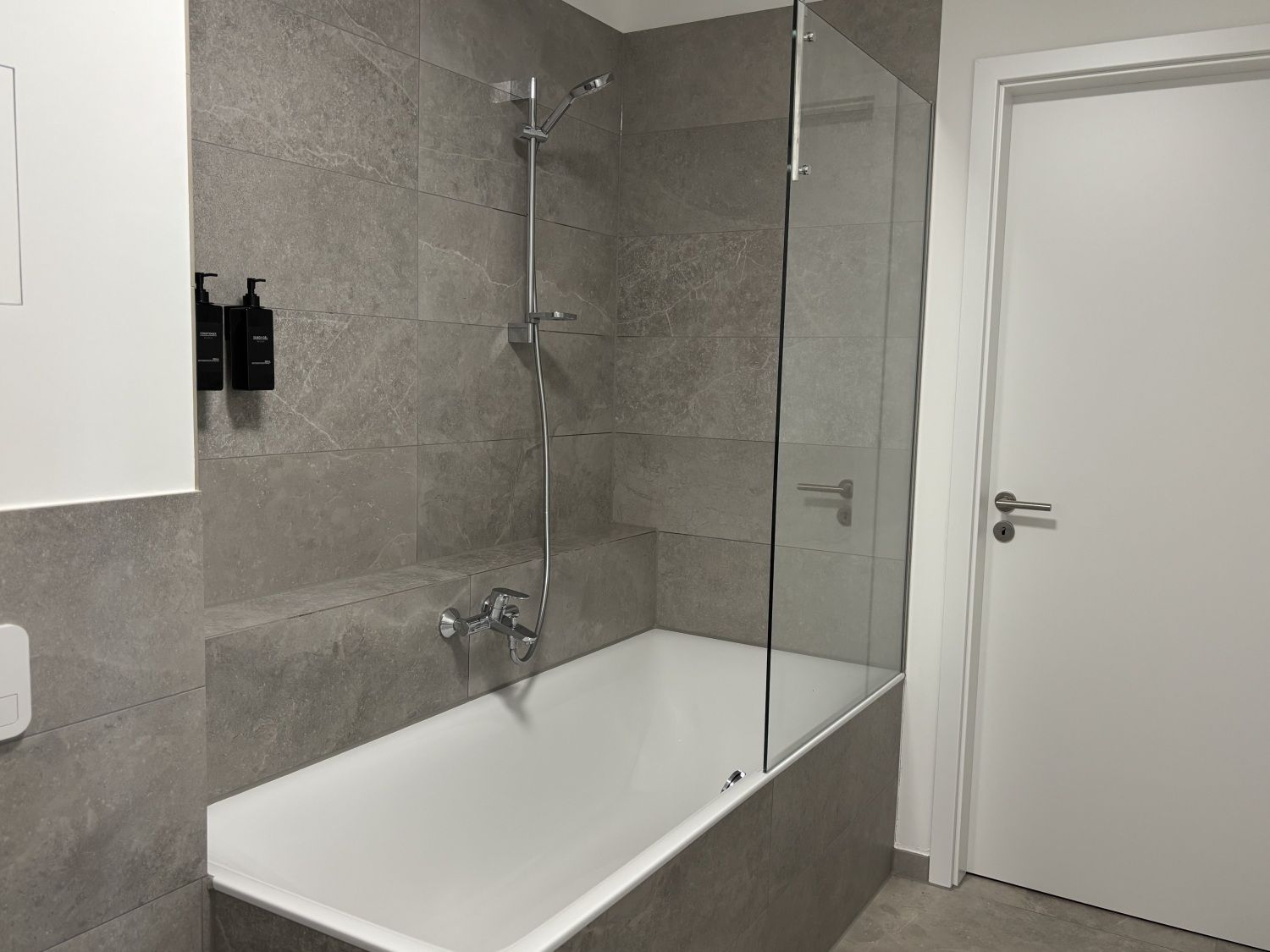 Badezimmer mit Badewanne und Duschabtrennung aus Glas