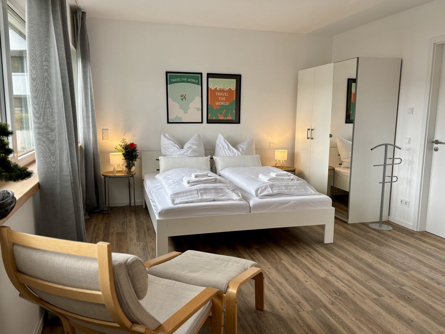 Schlafzimmer mit Doppelbett, Sessel und Spiegel