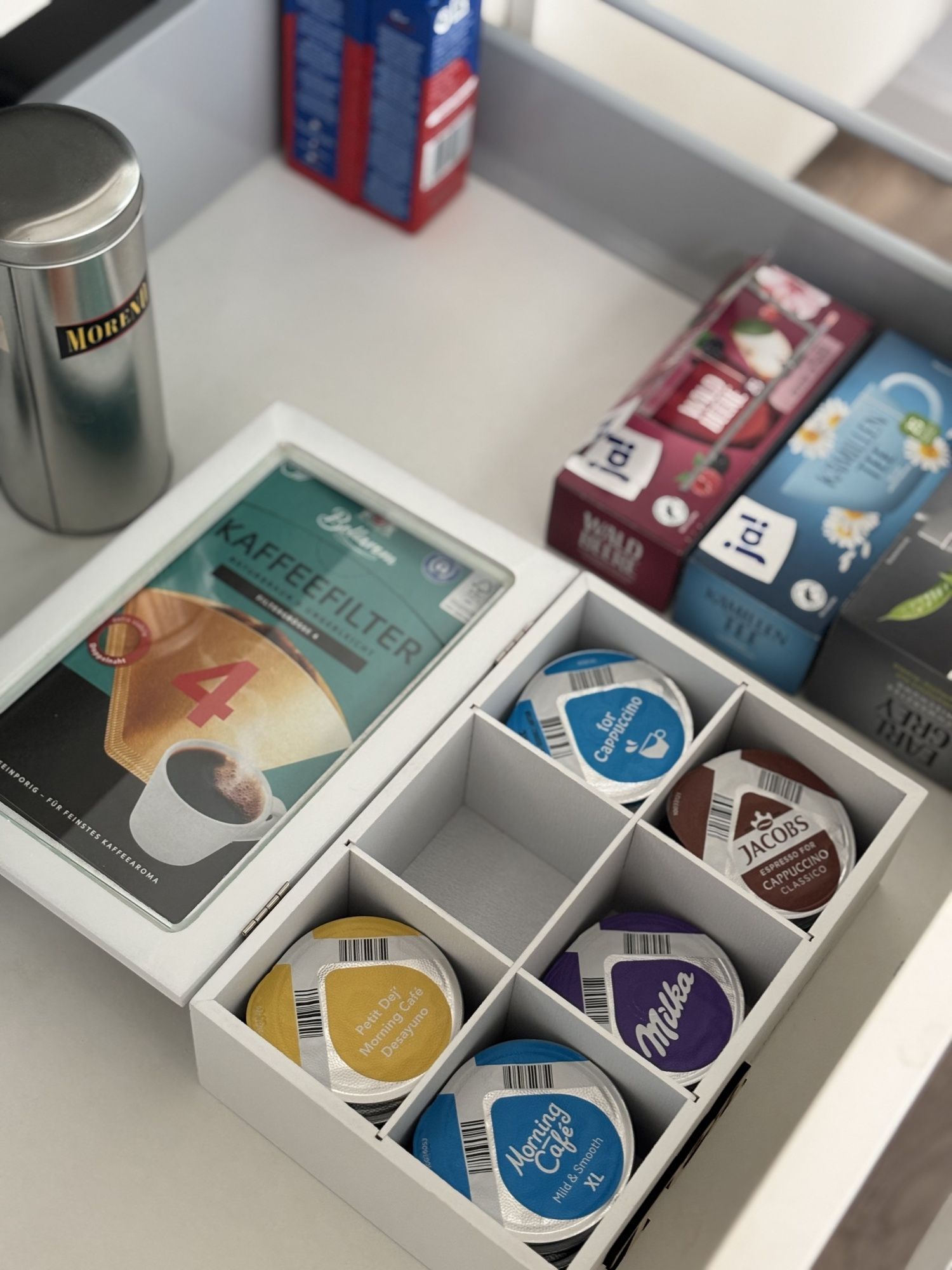 Schublade mit Kaffeekapseln, Tee und Filtern
